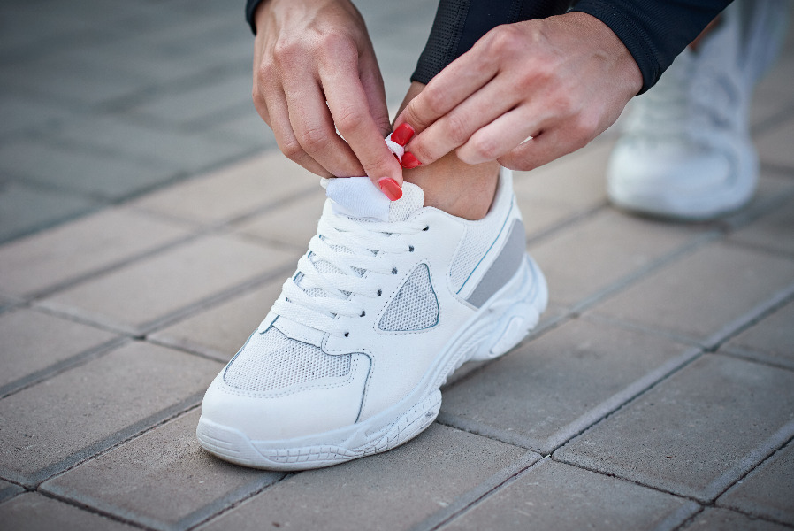 Cordones cruzados sobre unas zapatillas deportivas blancas